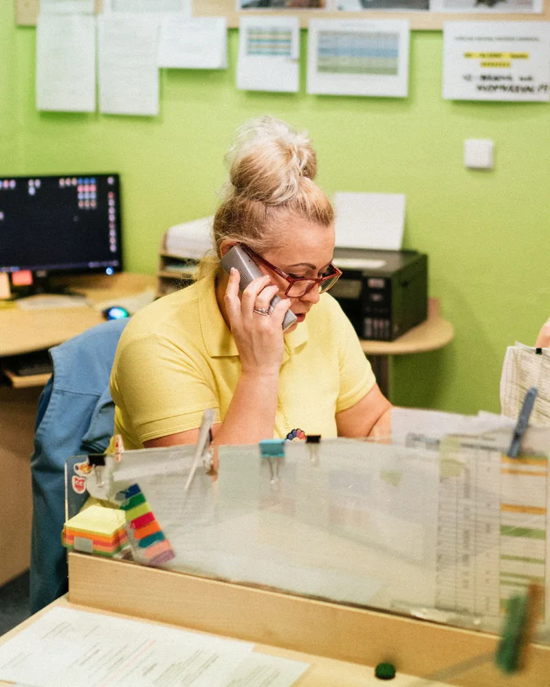 Au bureau d'une maison de retraite, une responsable au téléphone devant les plannings